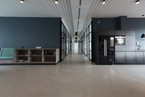 View of modern office hallway with overhead, hanging lights. 