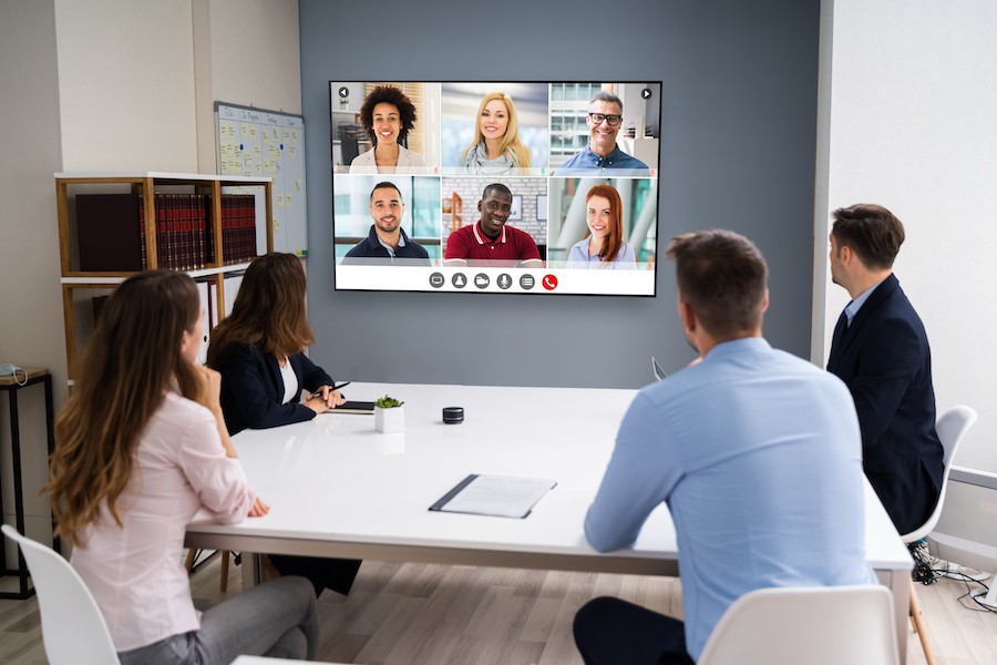 A video conferencing call connects in-person attendees with virtual attendees.